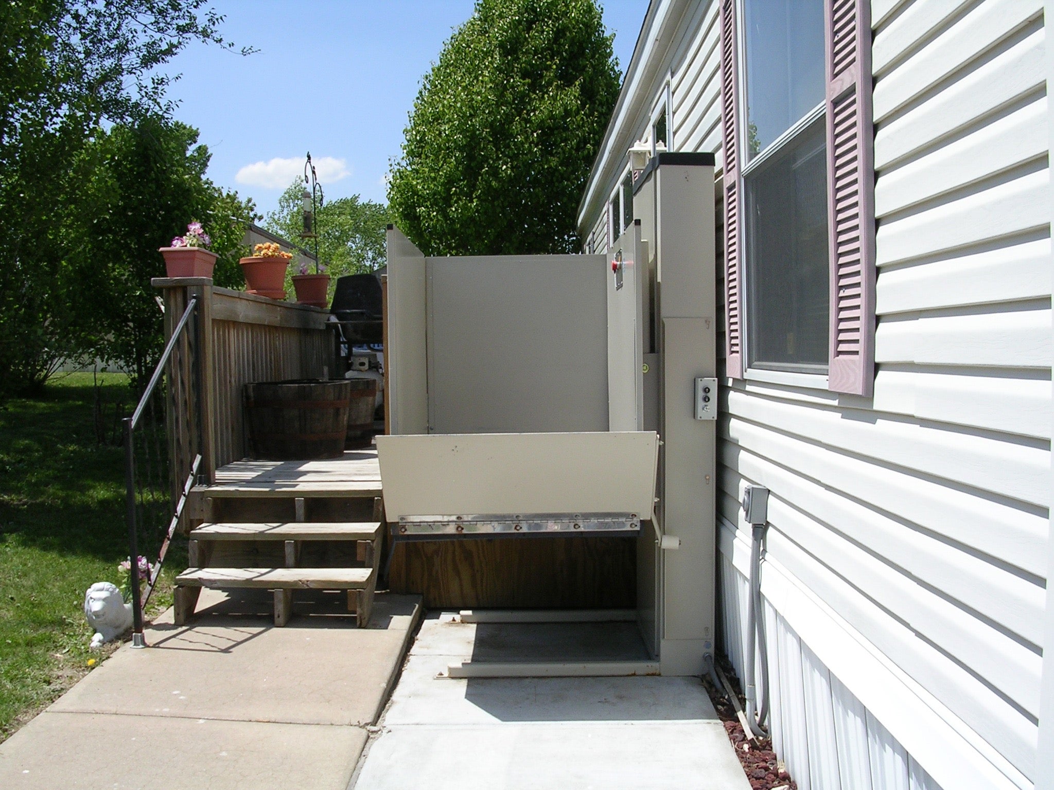 Mobile home with a wheelchair lift installed next to the steps.