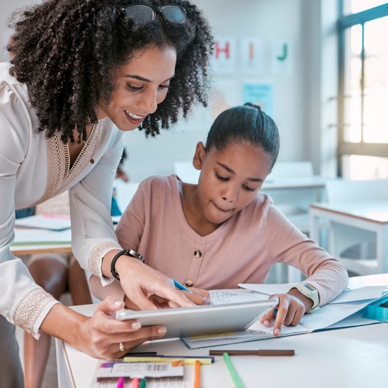 Teacher and student working together ona. computer